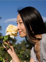 Woman Smelling A Yellow Rose