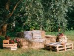 An outdoor seating area made of wooden pallets and hay bales